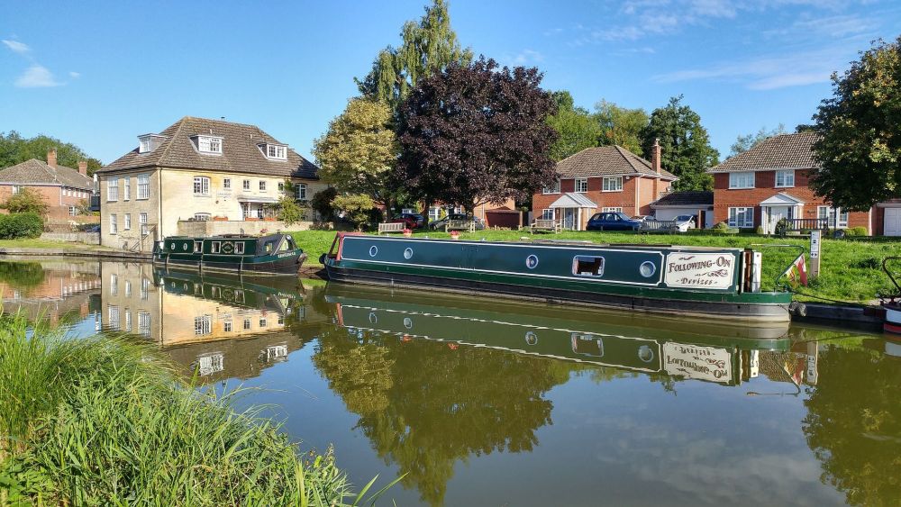 Two narrowboats moored up at the side of a canal